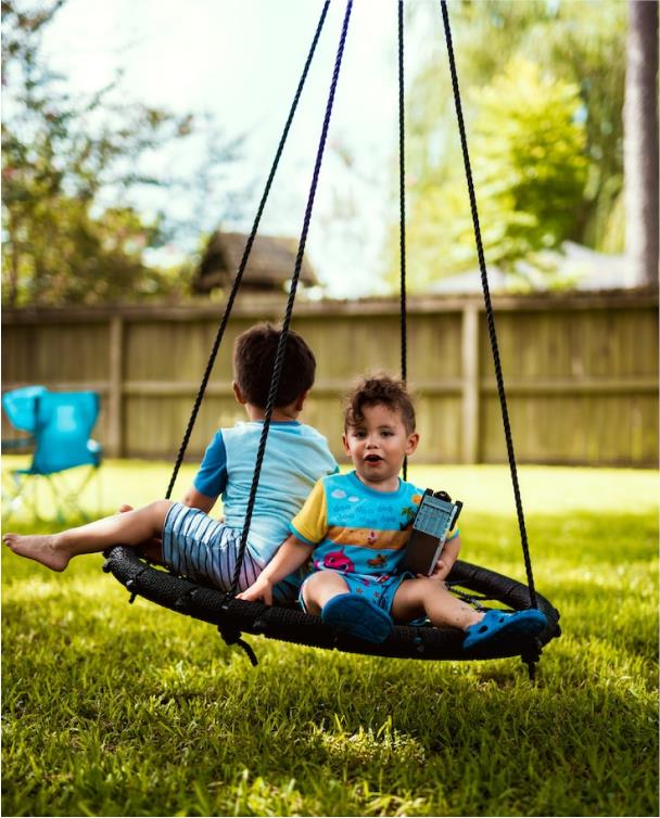 Twee kinderen schommelen op een nestschommel